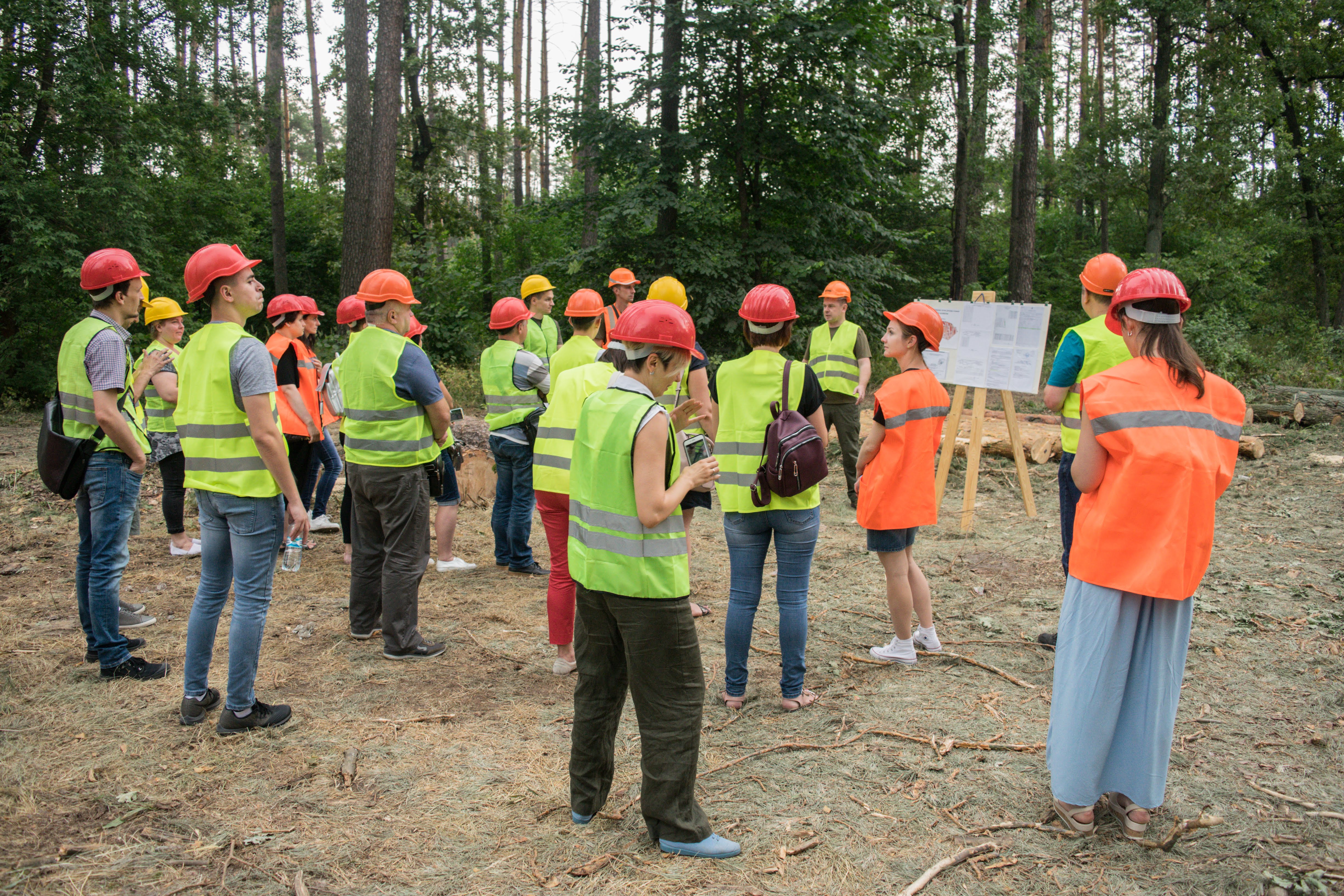 Ukrainian forest workers stand together in forest for team meeting